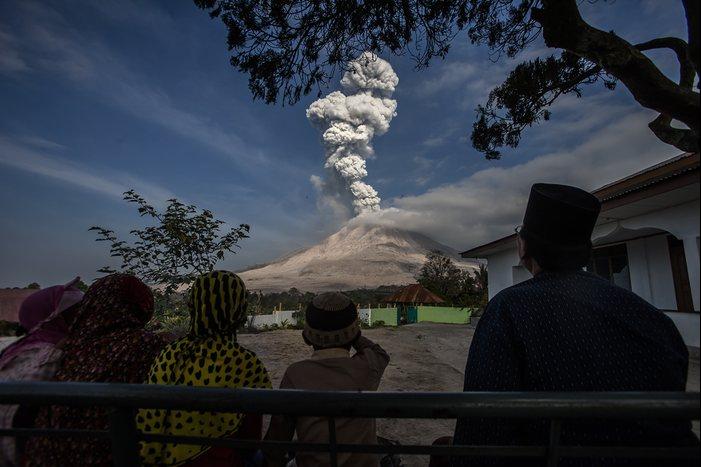 Жители Северной Суматры (Индонезия) наблюдают за извержением вулкана Синабунг